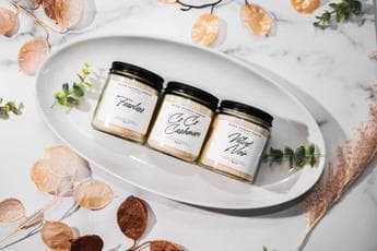 Three Black Essence Candles fragrance jars arranged on a white tray