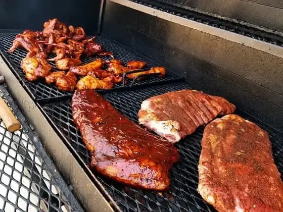 Barbecue spread beside a CaffyQ smoker