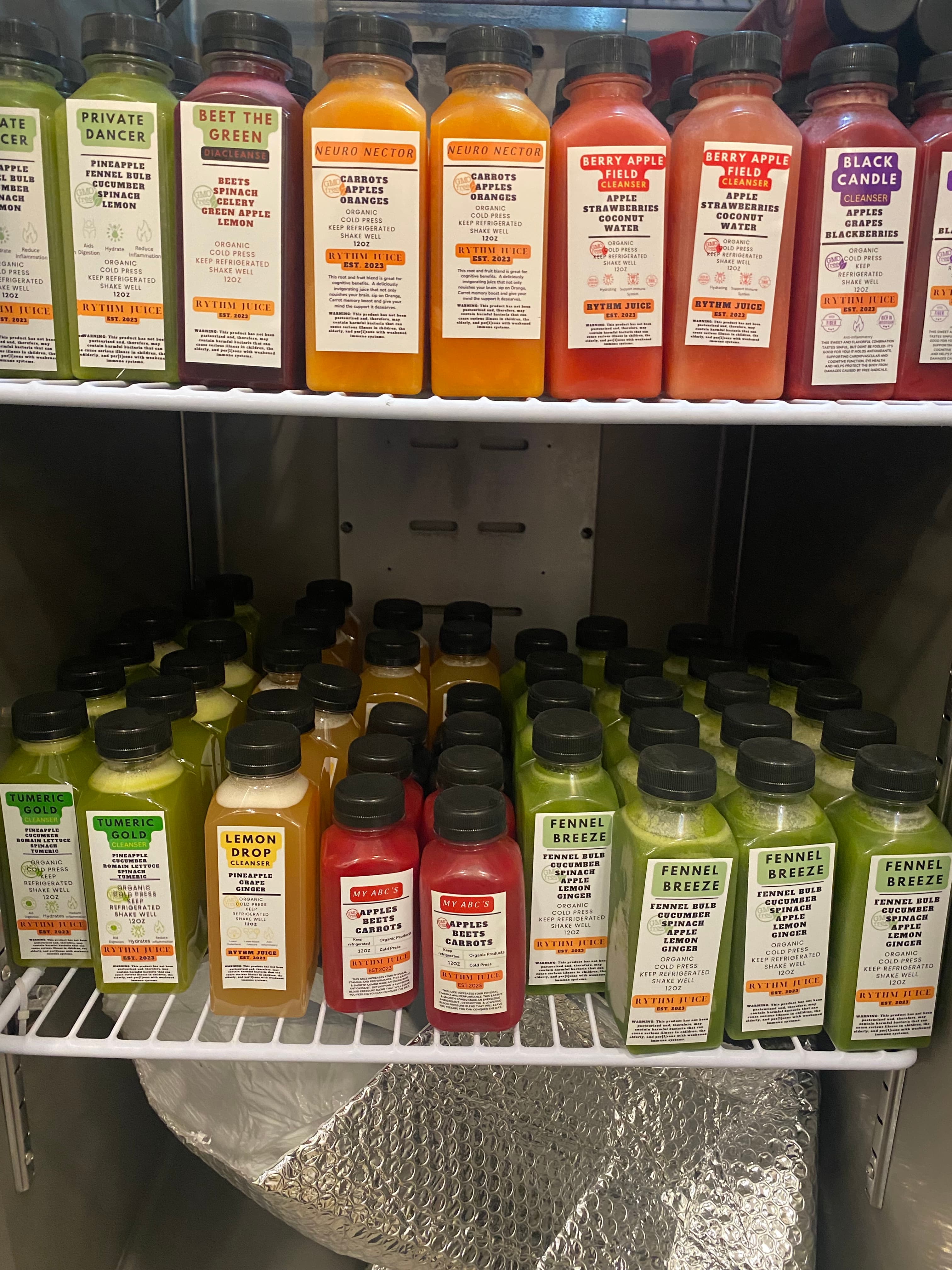 Refrigerated display filled with colorful Rythm Juice cold-pressed juice bottles